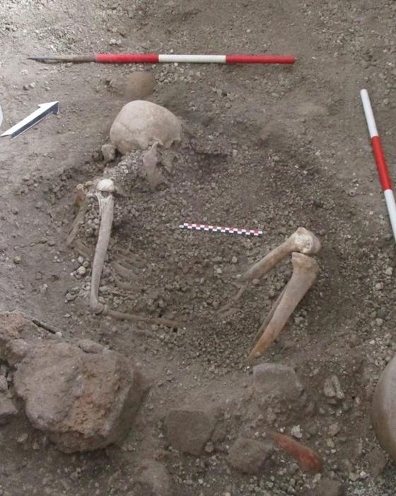 Skeleton of ‘individual 2’, a male aged around 50 years, who may have been aware of the danger and tried to protect himself with a round wooden object. The researchers found faint traces of it in the volcanic deposits. Image: Pompeii Archaeological Park